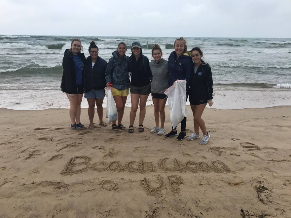 Group of students pose on the beach